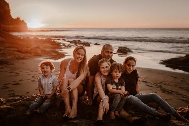 Brad's family sitting on the beach