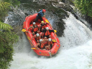 Leading edge team rafting down waterfall